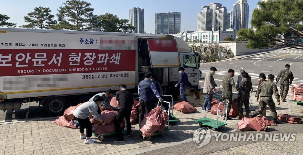 South Korean defense ministry officials prepare to shred confidential documents, as the relocation of their offices in Seoul began on April 8, 2022. (Yonhap)