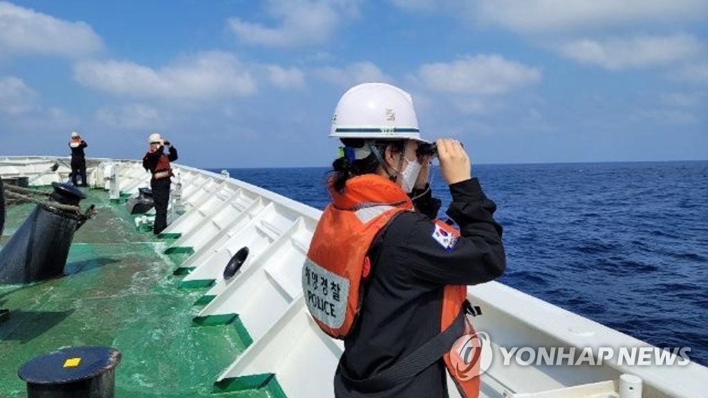 This photo provided by South Korea's foreign ministry shows Coast Guard officials conducting a search and rescue operation on April 9, 2022, for six South Koreans that went missing in waters west of Taiwan. (PHOTO NOT FOR SALE) (Yonhap)