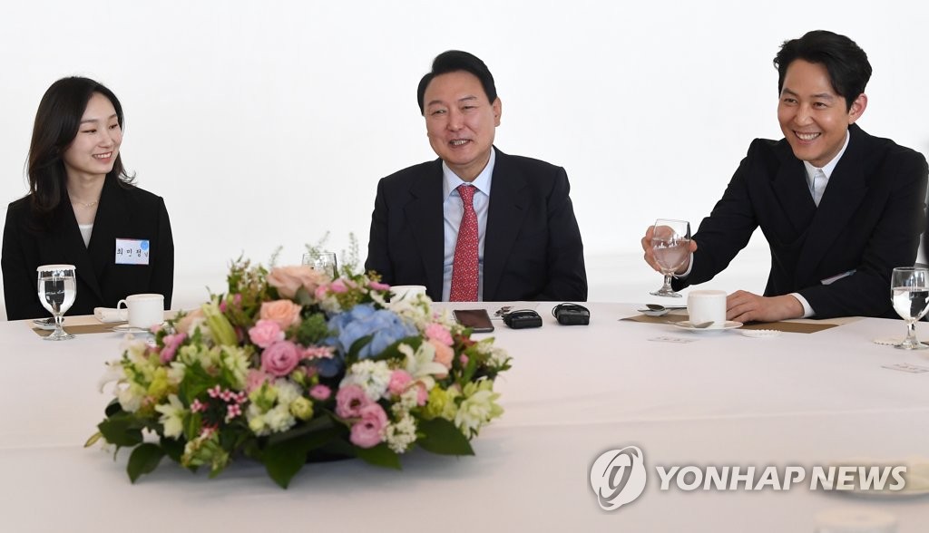 President-elect Yoon Suk-yeol (C) talks with actor Lee Jung-jae (R) and short track speed skater Choi Min-jeong during a meeting with figures from the fields of culture, sports and arts in Seoul on April 27, 2022. (Pool photo) (Yonhap)