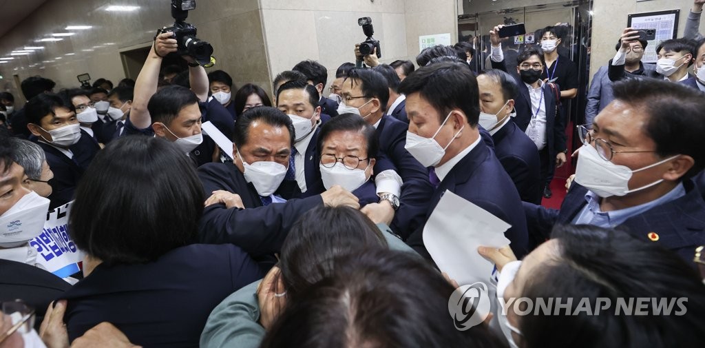 National Assembly Speaker Park Byeong-seug (C) struggles to make his way to the parliamentary plenary chamber, as members of the main opposition party strongly protest the ruling party's push to pass a bill on prosecution reform on April 30, 2022. (Pool photo) (Yonhap)