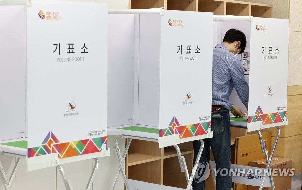 An election official checks a polling booth at a polling station in Seoul on May 25, 2022, one day ahead of the start of a two-day early voting period for the June 1 local elections. (Yonhap)
