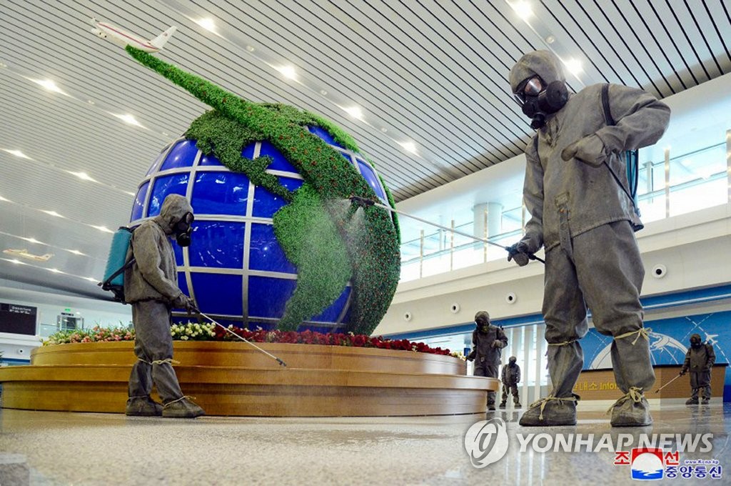 Des agents sanitaires pulvérisent du désinfectant à l'aéroport international de Pyongyang sur fond d'alerte maximale contre le nouveau coronavirus (Covid-19) sur cette photo non datée publiée le vendredi 10 juin 2022 par l'Agence centrale de presse nord-coréenne (KCNA). (Utilisation en Corée du Sud uniquement et redistribution interdite)