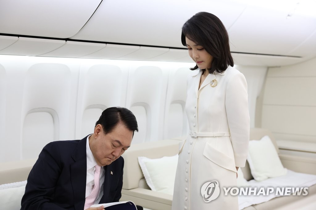 공군 1호기에서 자료 검토하는 윤석열 대통령과 함께 있는 부인 김건희 여사