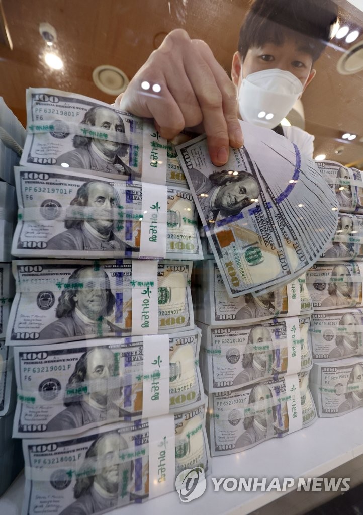 A clerk checks U.S. dollars at the headquarters of Hana Bank in Seoul on July 5, 2022. South Korea's foreign exchange reserves dropped US$9.43 billion on-month to US$438.28 billion as of end-June, marking the biggest monthly decline since 2008, according to the Bank of Korea. (Yonhap)