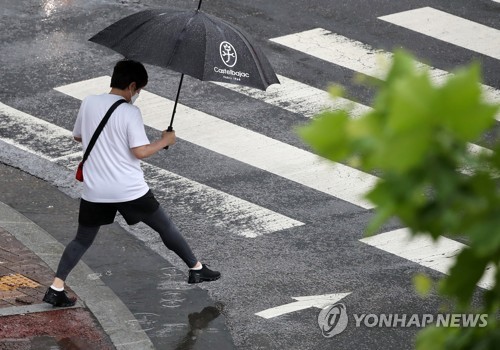 지난 18일 광주 서구 치평동에서 우산 쓴 시민이 길을 건너고 있다. [연합뉴스 자료사진]