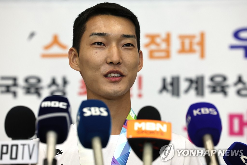 South Korean high jumper Woo Sang-hyeok speaks with reporters at Incheon International Airport, just west of Seoul, on July 21, 2022, after returning with the silver medal from the World Athletics Championships in Eugene, Oregon. (Yonhap)
