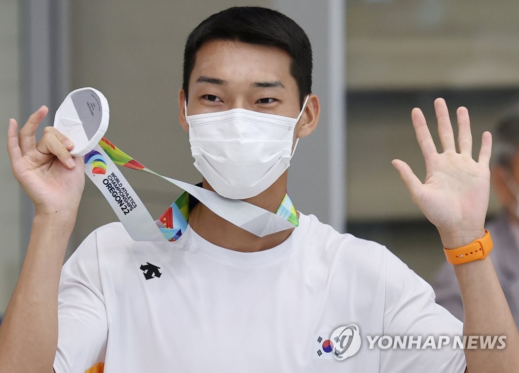 South Korean high jumper Woo Sang-hyeok holds up his silver medal from the World Athletics Championships in Eugene, Oregon, after arriving at Incheon International Airport, just west of Seoul, on July 21, 2022. (Yonhap)