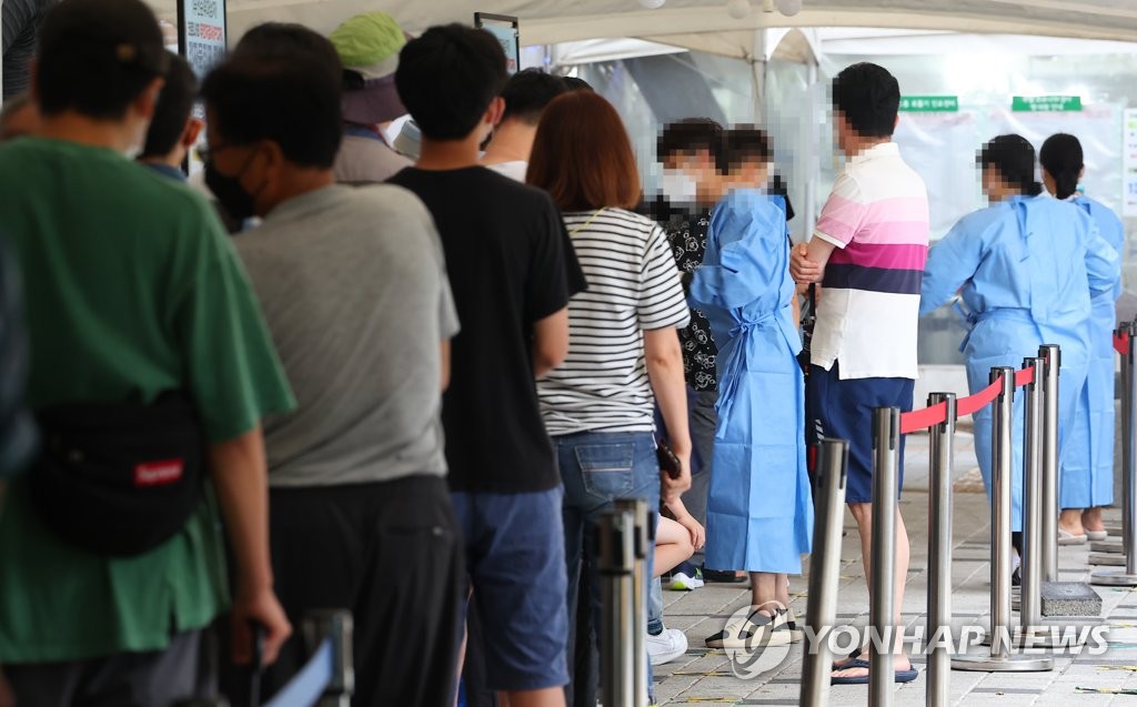 ソウル市内の新型コロナウイルス検査所で順番を待つ人々＝８日、ソウル（聯合ニュース）