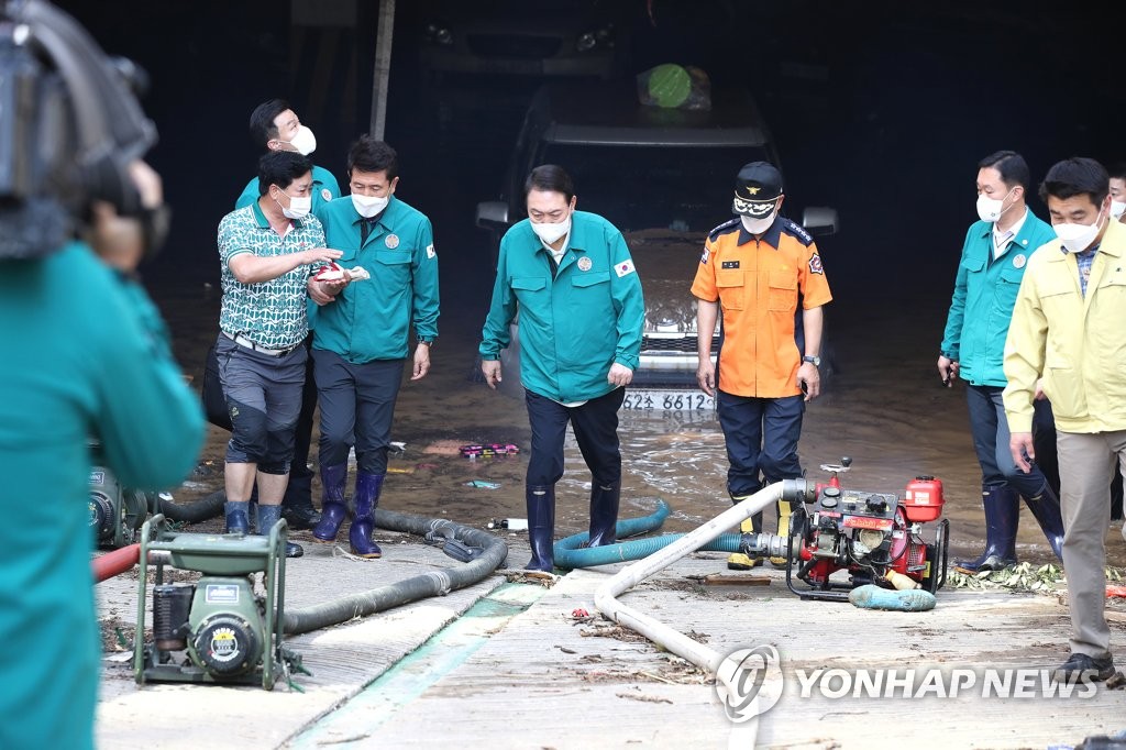 President Yoon Suk-yeol (C) visits the underground parking lot of an apartment complex in Pohang, 270 kilometers southeast of Seoul, where flooding caused by Typhoon Hinnamnor killed seven people, on Sept. 7, 2022. (Pool photo) (Yonhap)