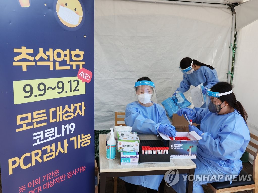 Medical workers prepare for COVID-19 tests at a makeshift testing station at a highway service area in the city of Yongin, south of Seoul, on Sept. 7, 2022. (Yonhap)