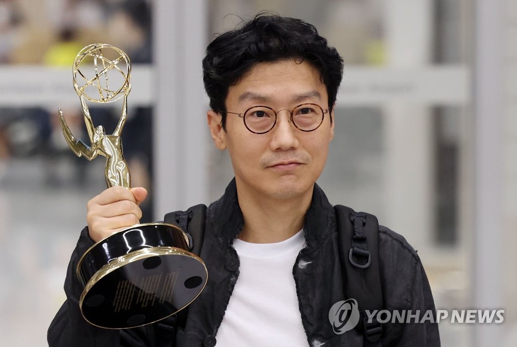El director surcoreano Hwang Dong-hyuk, quien ganó el premio al mejor director en los Premios Emmy de este año, posa para una foto con su trofeo, 15 de septiembre de 2022, tras llegar al Aeropuerto Internacional de Incheon, al oeste de Seúl.