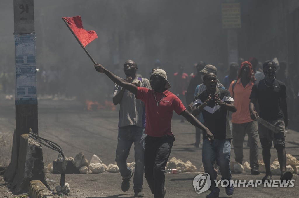 적색기 흔들며 시위하는 아이티 남성