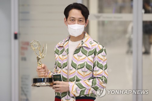 South Korean actor Lee Jung-jae, who won best drama series actor with "Squid Game" at this year's Primetime Emmy Awards, poses for a photo with his Emmy trophy upon arrival at Incheon International Airport in Incheon, west of Seoul, on Sept. 18, 2022. (Yonhap)