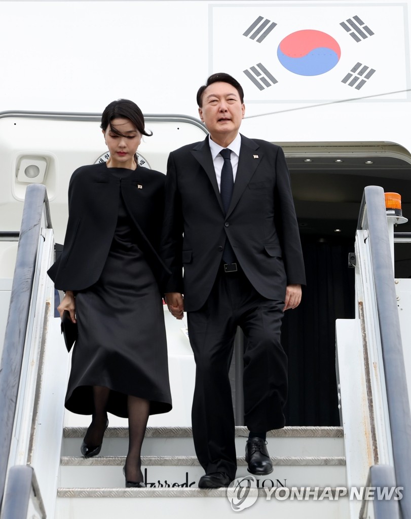 El presidente surcoreano, Yoon Suk-yeol (dcha.), y su esposa, Kim Keon-hee, llegan al Aeropuerto de Londres Stansted, el 18 de septiembre de 2022 (hora local), para asistir al funeral de Estado por la reina Isabel II.