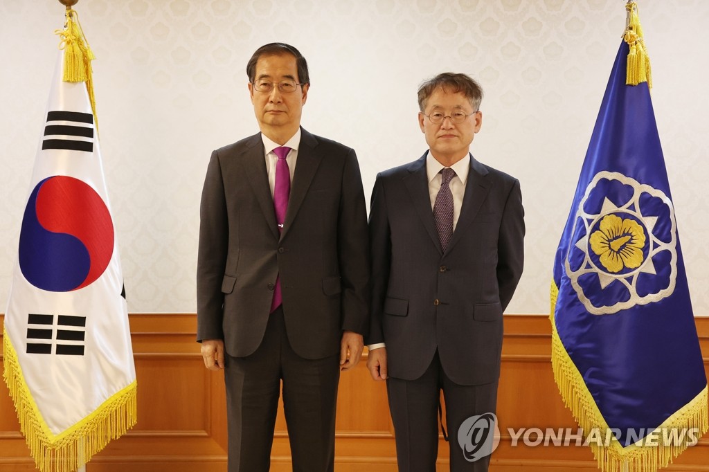 This file photo shows Choi Kyong-lim (R), South Korea's new ambassador for cooperation with the Bureau International des Expositions, posing for a photo with Prime Minister Han Duck-soo on Sept. 30, 2022. (Yonhap)