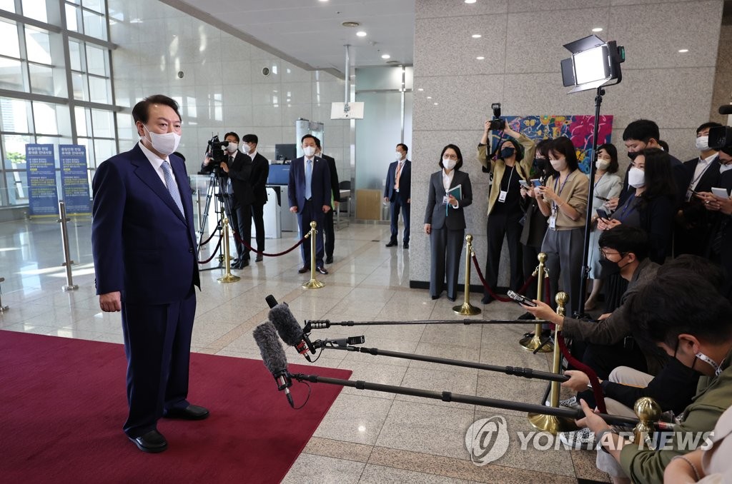 El presidente surcoreano, Yoon Suk-yeol (izda.), habla ante los reporteros, el 7 de octubre de 2022, a su llegada a la oficina presidencial, en Seúl.