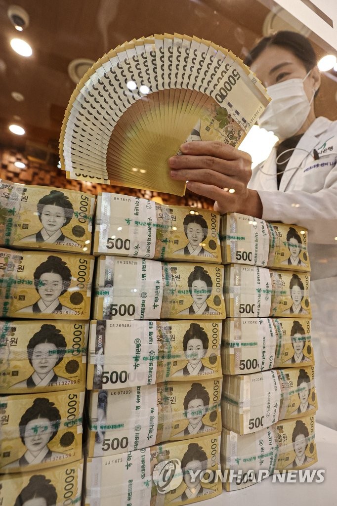 A clerk sorts 50,000 won banknotes at a bank in Seoul on Oct. 24, 2022. South Korea's financial authorities announced plans the previous day to expand liquidity supply programs to at least 50 trillion won (US$34.7 billion) as part of efforts to calm corporate bond market jitters. (Yonhap)