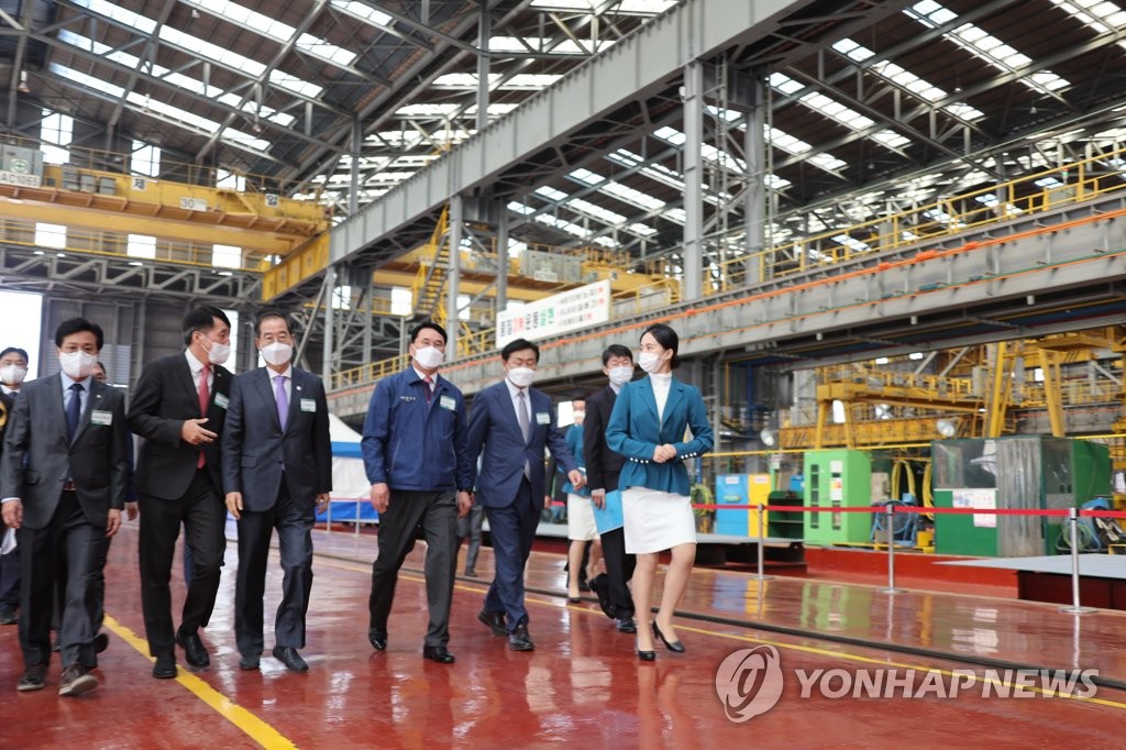El primer ministro surcoreano, Han Duck-soo (tercero por la izda.), asiste a una ceremonia para conmemorar la reanudación de las operaciones en un astillero de Hyundai Heavy, el 28 de octubre de 2022, en la ciudad portuaria de Gunsan, a 275 kilómetros al sudoeste de Seúl.