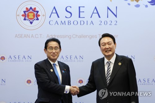 会談で握手を交わす韓国の尹大統領（右）と岸田首相＝１３日、プノンペン（聯合ニュース）