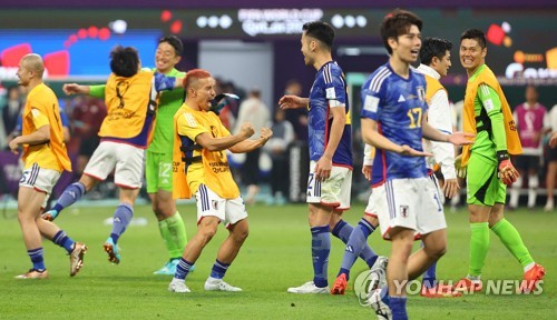 Japanese players celebrate their 2-1 victory over Germany in their Group E match at the FIFA World Cup at Khalifa International Stadium in Al Rayyan, west of Doha, on Nov. 23, 2022. (Yonhap)