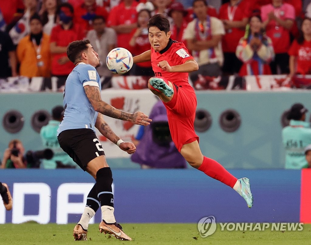 Lee Kang-in of South Korea (R) battles Jose Maria Gimenez of Uruguay during their Group H match at the FIFA World Cup at Education City Stadium in Al Rayyan, west of Doha, on Nov. 24, 2022. (Yonhap)