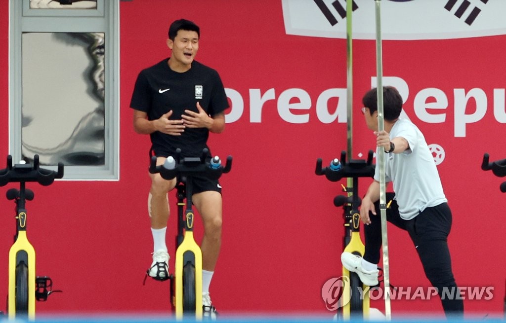 South Korean defender Kim Min-jae (L) rides a stationary bicycle during a training session for the FIFA World Cup at Al Egla Training Site in Doha on Dec. 1, 2022. (Yonhap)