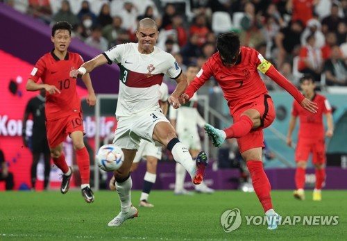 Son Heung-min of South Korea (R) fires a shot past Pepe of Portugal during the countries' Group H match at Education City Stadium in Al Rayyan, west of Doha, on Dec. 2, 2022. (Yonhap)