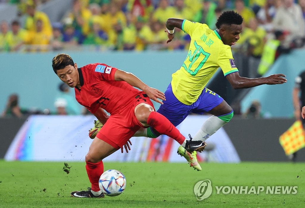 Hwang Hee-chan of South Korea (L) and Vinicius Junior of Brazil battle for the ball during the countries' round of 16 match at the FIFA World Cup at Stadium 974 in Doha on Dec. 5, 2022. (Yonhap)