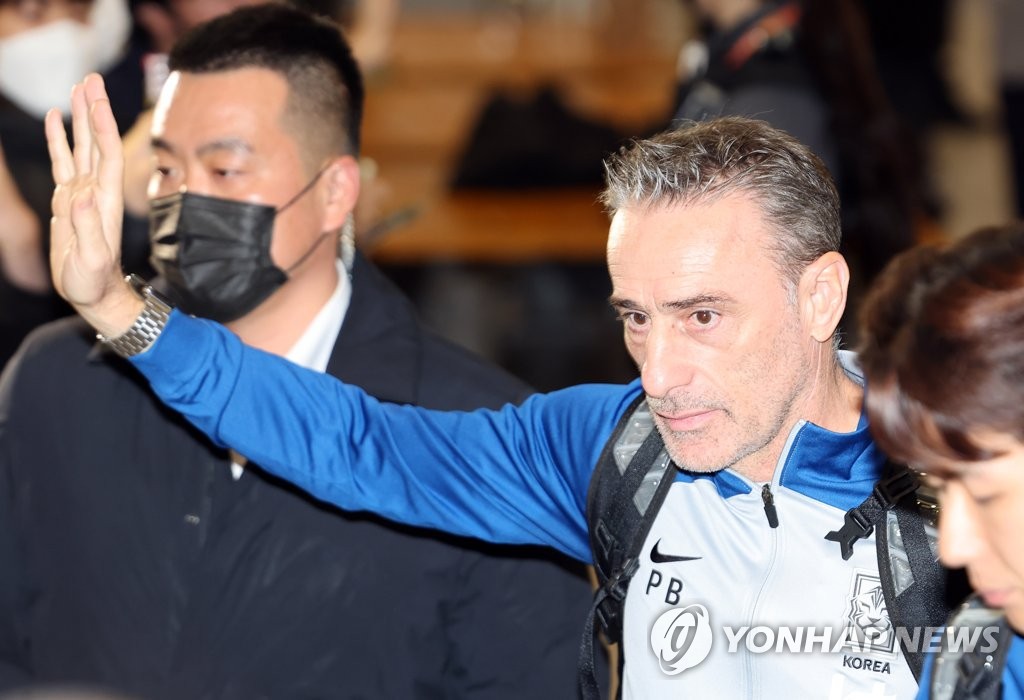 El director técnico de Corea del Sur, Paulo Bento (segundo por la dcha.), saluda a los fanes, en el Aeropuerto Internacional de Incheon, justo al oeste de Seúl, luego de regresar al país, el 7 de diciembre de 2022, tras su participación en la Copa Mundial de Catar.