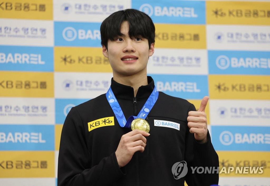 South Korean swimmer Hwang Sun-woo poses with his gold medal from the men's 200-meter freestyle at the FINA Short Course World Swimming Championships after arriving at Incheon International Airport, west of Seoul, on Dec. 20, 2022. (Yonhap)