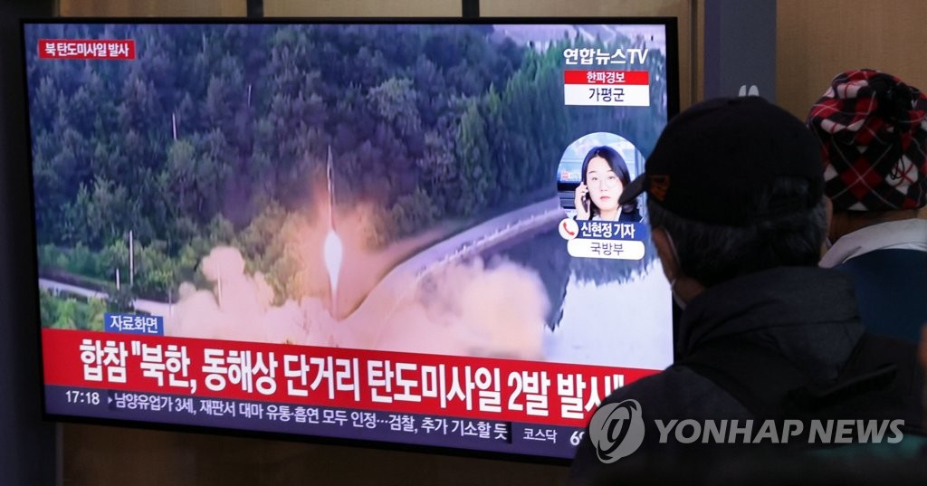 ソウル駅のテレビで北朝鮮による弾道ミサイル発射のニュースを見る市民ら＝２３日、ソウル（聯合ニュース）