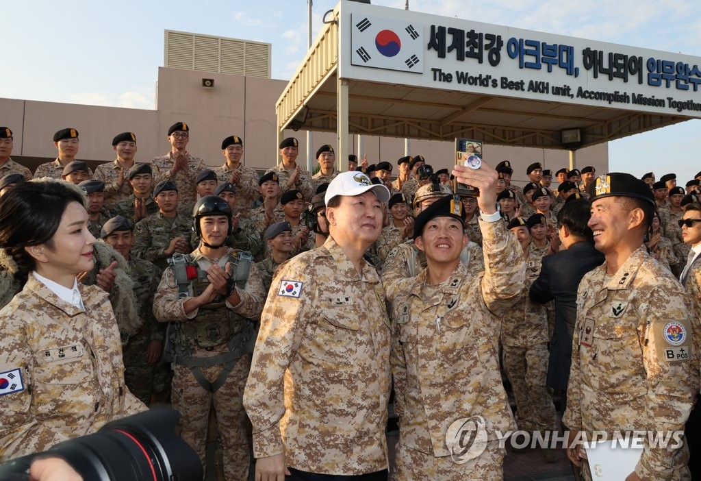 Le président Yoon Suk Yeol prend le dimanche 15 janvier 2023 un selfie avec un soldat sud-coréen de l'unité Akh à Abou Dhabi. A sa droite, se trouve son épouse Kim Keon Hee.