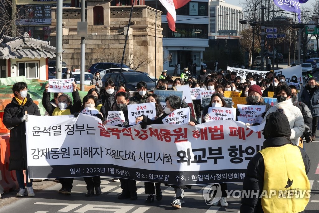 A group of progressive activists marches toward the foreign ministry in Seoul on Jan. 18, 2023, to convey their letter of protest against the South Korean government's solution for addressing the issue of compensation for wartime forced labor. (Yonhap)