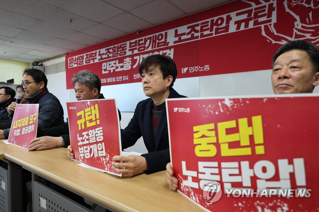 Members of the Korean Confederation of Trade Unions hold signs protesting the Yoon Suk Yeol government's labor policy during a press conference on Feb. 20, 2023. (Yonhap)