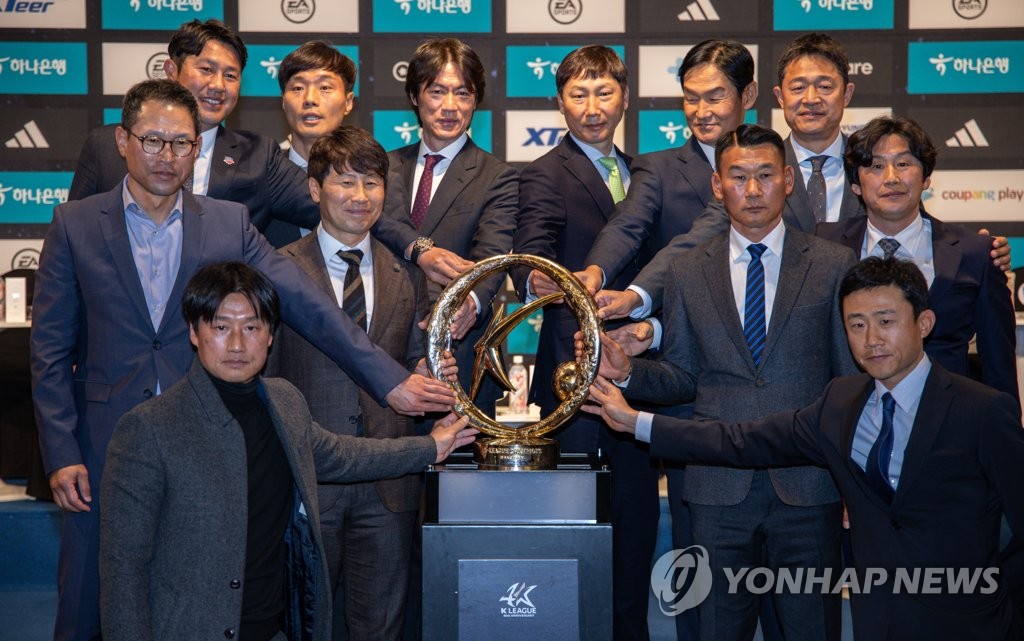 Head coaches of the 12 K League 1 clubs pose next to the K League 1 championship trophy during the K League 1 media day in Seoul on Feb. 20, 2023. (Yonhap)