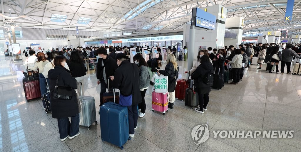 仁川国際空港のチェックインカウンターで日本行き航空便の搭乗客が列を作っている＝（聯合ニュース）