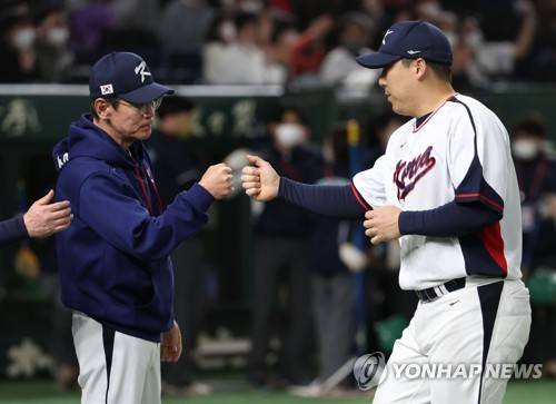 South Korea captain Kim Hyun-soo (R) bumps fists with manager Lee Kang-chul after a 7-3 win over the Czech Republic in a Pool B game at the World Baseball Classic at Tokyo Dome in Tokyo on March 12, 2023. (Yonhap)