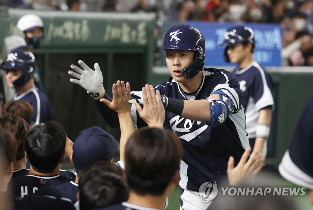 Park Kun-woo of South Korea high-fives teammates in the dugout after hitting a grand slam against China during the top of the fourth inning of a Pool B game at the World Baseball Classic at Tokyo Dome in Tokyo on March 13, 2023. (Yonhap)