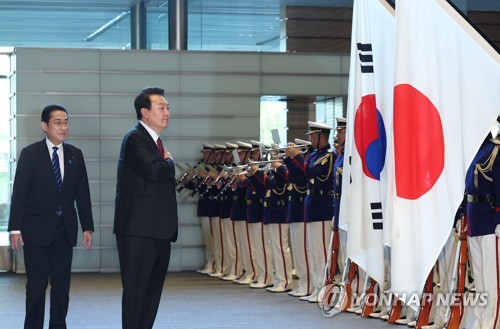 El presidente Yoon Suk Yeol (segundo por la izda.) saluda a la bandera nacional durante una inspección a una guardia de honor antes de los diálogos cumbre con el primer ministro japonés, Fumio Kishida, en la residencia del último, en Tokio, el 16 de marzo de 2023. Esta es la primera cumbre entre Corea del Sur y Japón en 12 años.