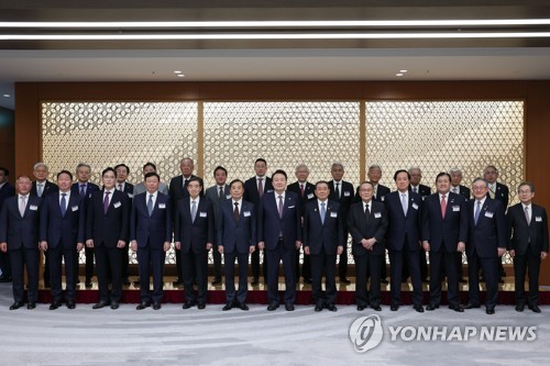 President Yoon Suk Yeol (7th from L) poses for a photo with business leaders from South Korea and Japan during a business roundtable in Tokyo on March 17, 2023, on the second day of Yoon's two-day visit to the neighboring country. Yoon held a summit the previous day with Japanese Prime Minister Fumio Kishida and agreed to normalize bilateral relations strained over wartime history and other issues. (Yonhap)
