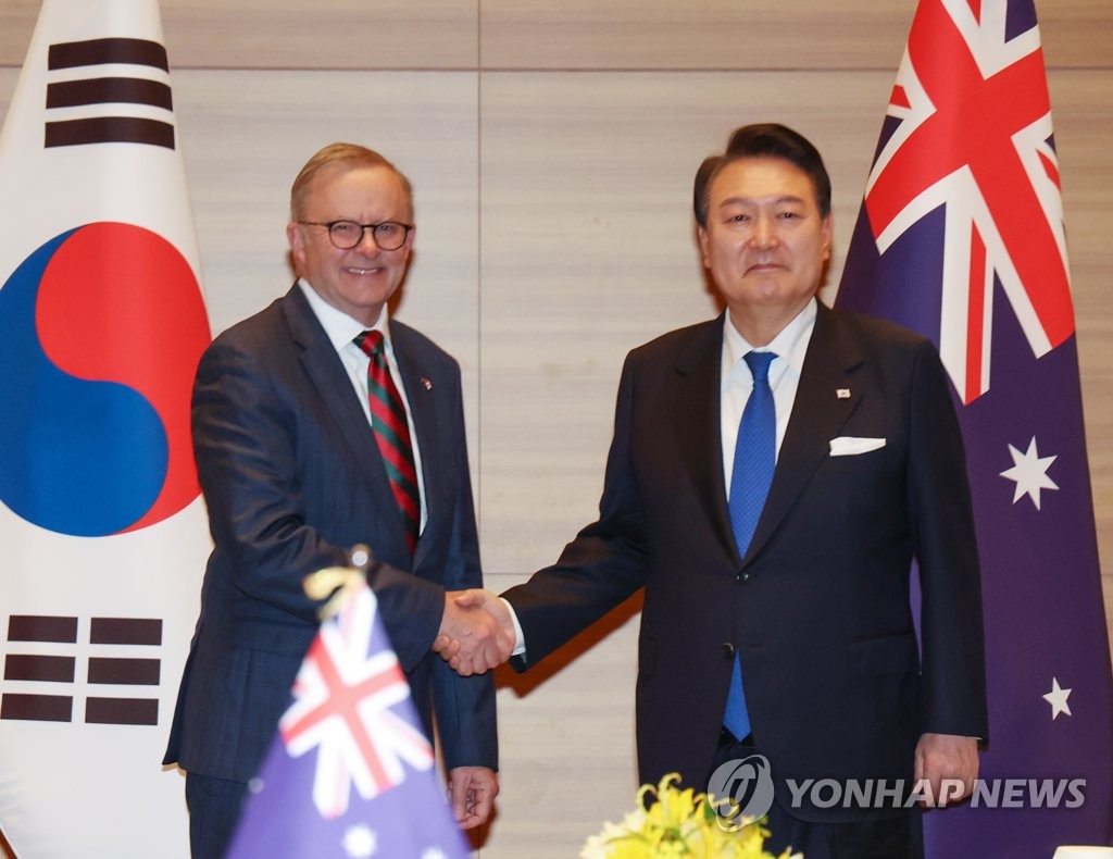 South Korean President Yoon Suk Yeol (R) and Australian Prime Minister Anthony Albanese shake hands during their summit at a hotel in Hiroshima, Japan, on May 19, 2023. (Yonhap)