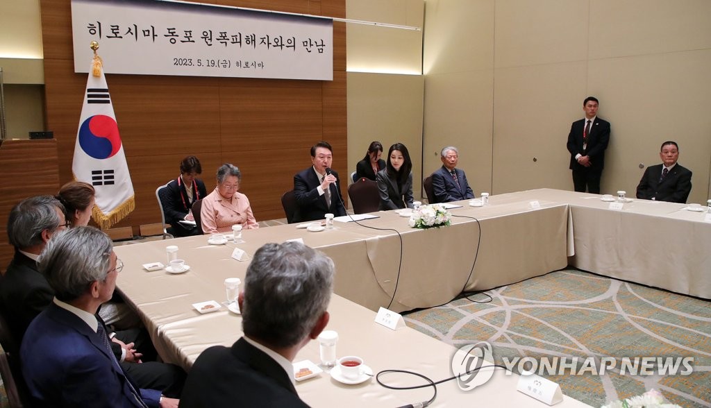 Le président sud-coréen Yoon Suk Yeol (2e à gauche, rangée arrière) et son épouse Kim Keon Hee (2e à droite, rangée arrière) rencontrent un groupe de victimes coréennes du bombardement atomique d'Hiroshima dans un hôtel d'Hiroshima, au Japon, le 19 mai 2023.