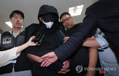 El hombre treintañero que abrió la puerta de un avión de Asiana Airlines, justo antes del aterrizaje en el Aeropuerto Internacional de Daegu, a 237 kilómetros al sureste de Seúl, es trasladado a un tribunal de Daegu, el 28 de mayo de 2023, para ser interrogado.
