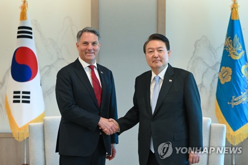 President Yoon Suk Yeol (R) and Australian Deputy Prime Minister Richard Marles shake hands during their meeting at the presidential office in Seoul on May 30, 2023, in this photo provided by Yoon's office. (PHOTO NOT FOR SALE) (Yonhap)
