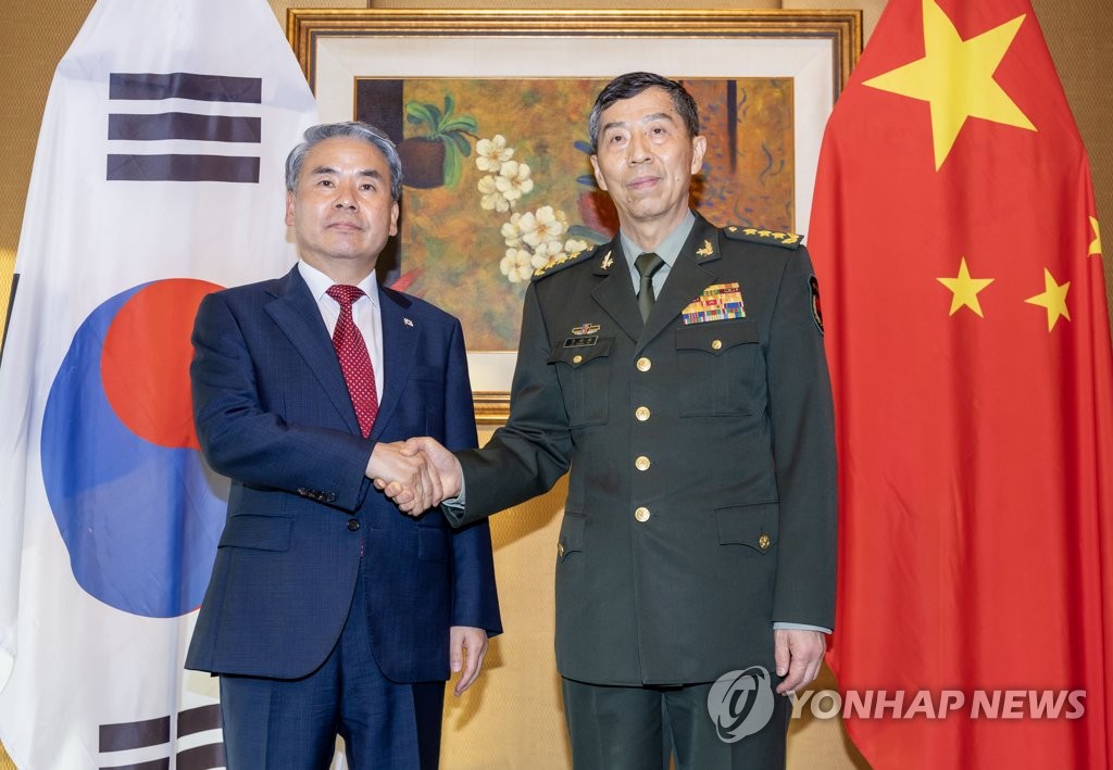El ministro de Defensa surcoreano, Lee Jong-sup (izda.), y su homólogo chino, Li Shangfu, posan ante la cámara, el 3 de junio de 2023, durante su encuentro para diálogos bilaterales al margen del Diálogo de Shangri La, en Singapur.