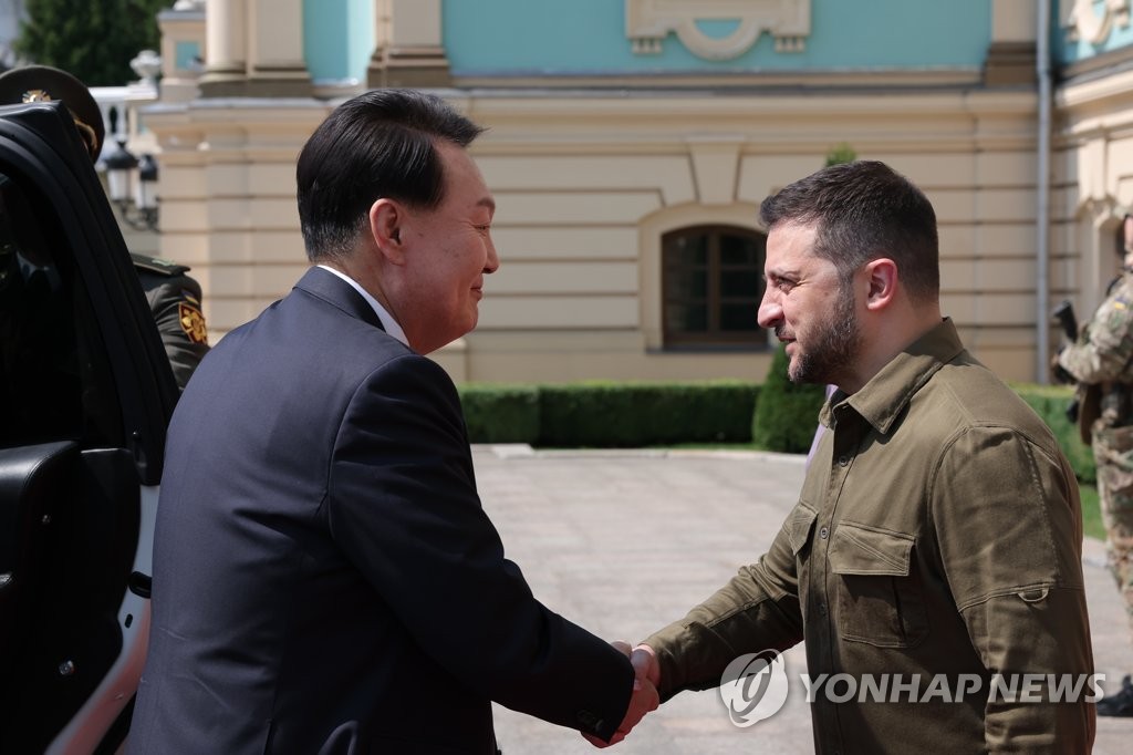 South Korean President Yoon Suk Yeol (L) greets Ukrainian President Volodymyr Zelenskyy after arriving at the Mariinskyi Palace, the official residence of the president of Ukraine, in Kyiv on July 15, 2023, in this photo provided by South Korea's presidential office. (PHOTO NOT FOR SALE) (Yonhap)