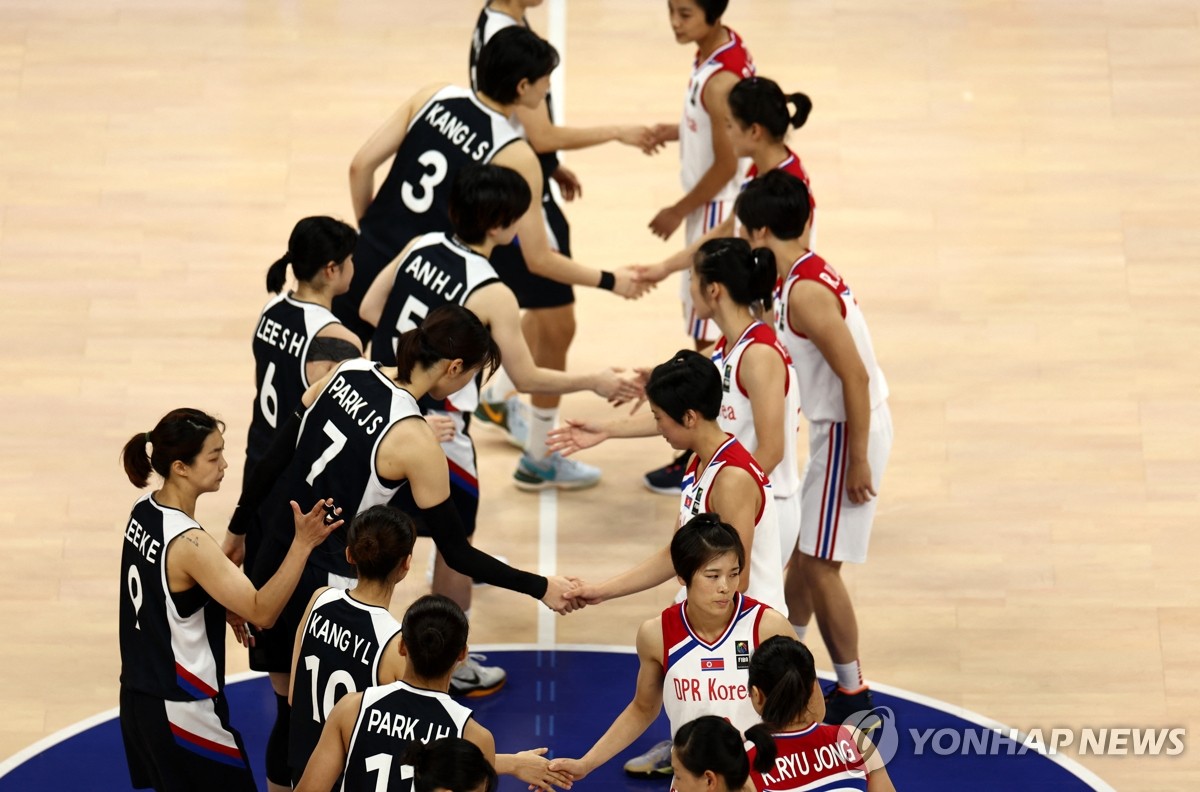 로이터 통신 사진에서 지난 10월 5일 중국 항저우 항저우 올림픽센터 체육관에서 열린 여자농구 동메달 결정전을 앞두고 한국(검은색 유니폼 왼쪽)과 북한 선수들이 악수하고 있다. .  , 2023. (연합)