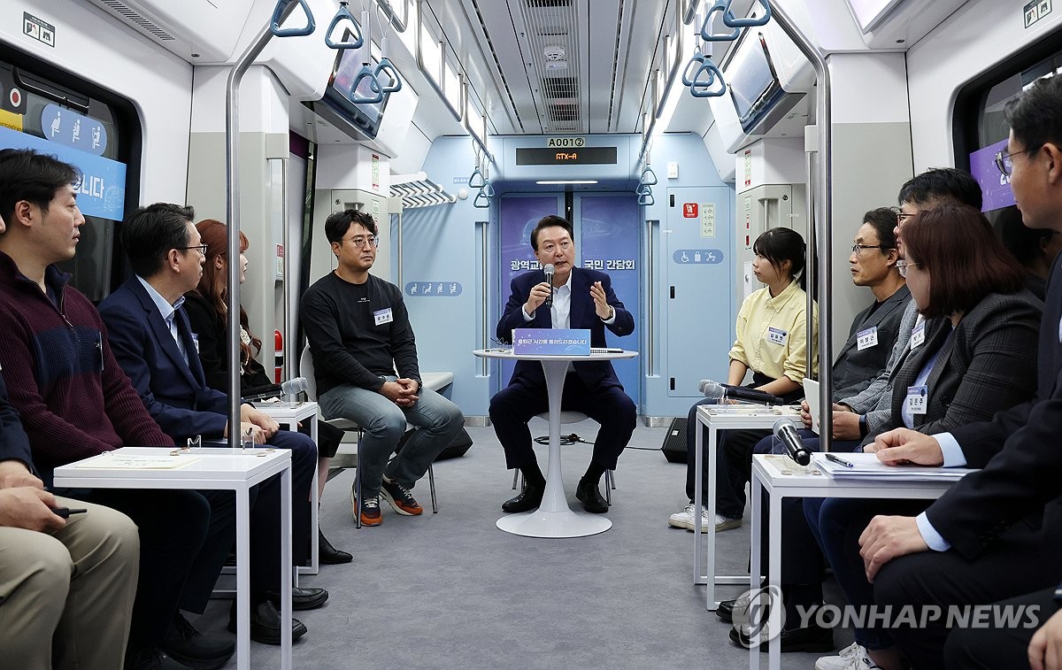 President Yoon Suk Yeol (C) speaks during a public meeting over intercity transport on a train at Dongtan Station in Hwaseong, 45 kilometers south of Seoul, on Nov. 6, 2023. (Pool photo) (Yonhap)