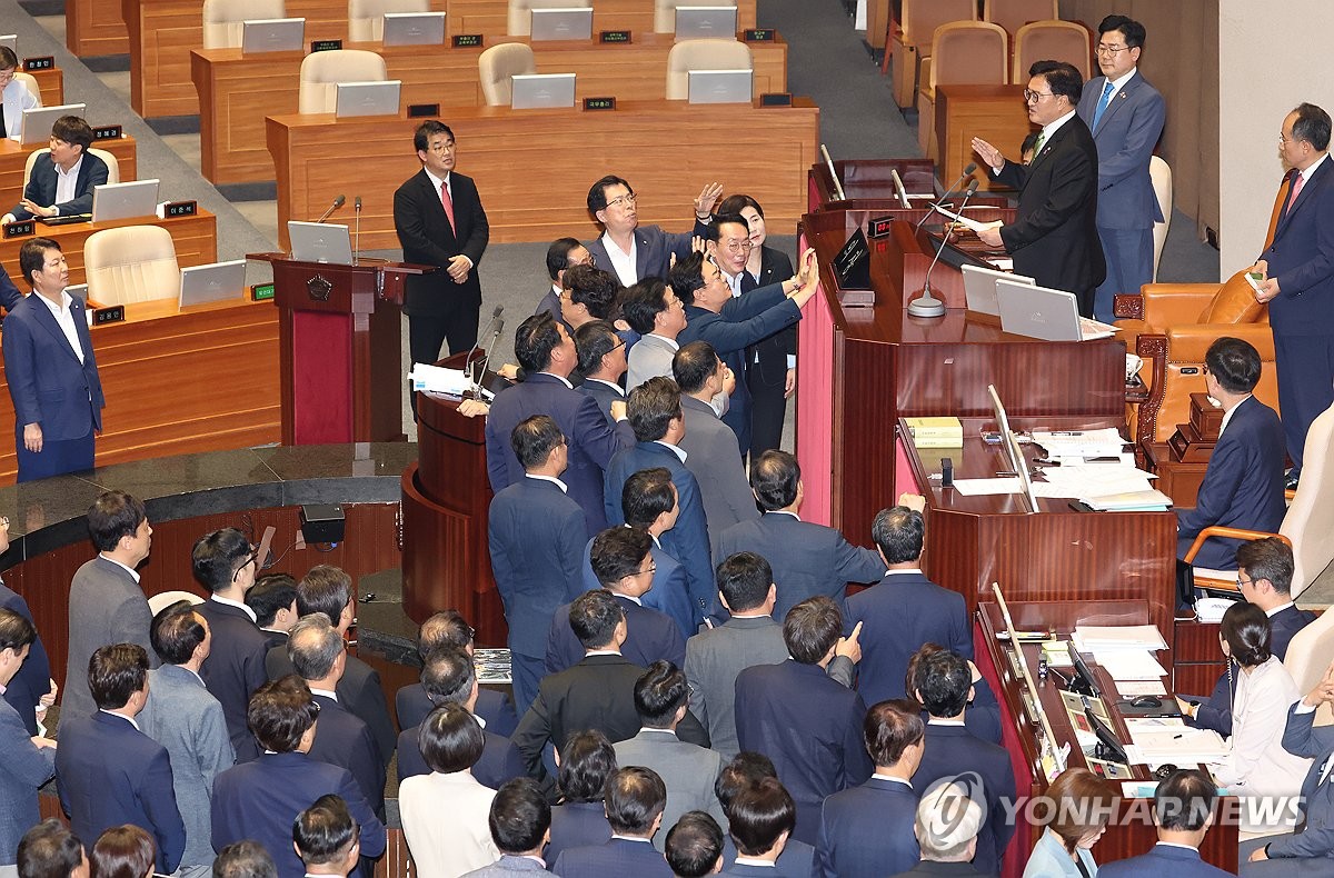 Los legisladores del gobernante Partido del Poder Popular presentan una protesta contra el presidente Woon Won-shik (tercero desde la derecha, de pie en el podio) durante una sesión plenaria de la Asamblea Nacional en Seúl el 4 de julio de 2024. Woo pidió la suspensión de su obstruccionismo, que tenía como objetivo bloquear una votación sobre un controvertido proyecto de ley liderado por la oposición para introducir una investigación especial sobre la muerte de un marine, después de que expirara el plazo de 24 horas para obstruir la votación. (Yonhap)