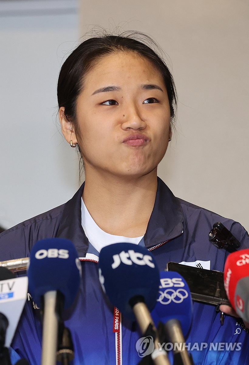 한국 배드민턴 선수 안세영이 파리올림픽 여자단식 금메달을 안고 귀국한 뒤 2024년 8월 7일 서울 서쪽 인천국제공항에서 기자의 질문을 듣고 있다. (연합)